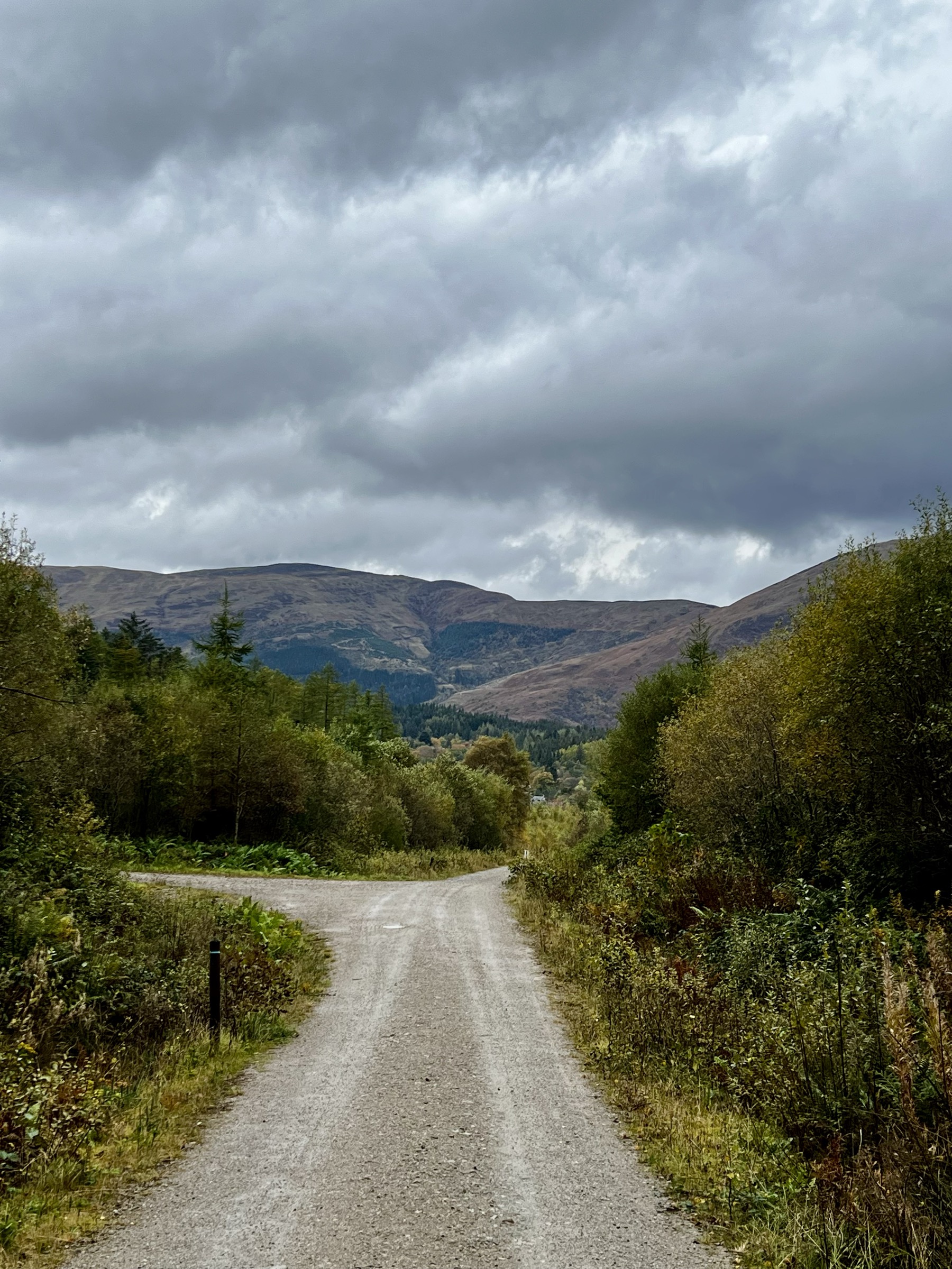 Une route lente qui traverse une vallée dans les Highlands écossais