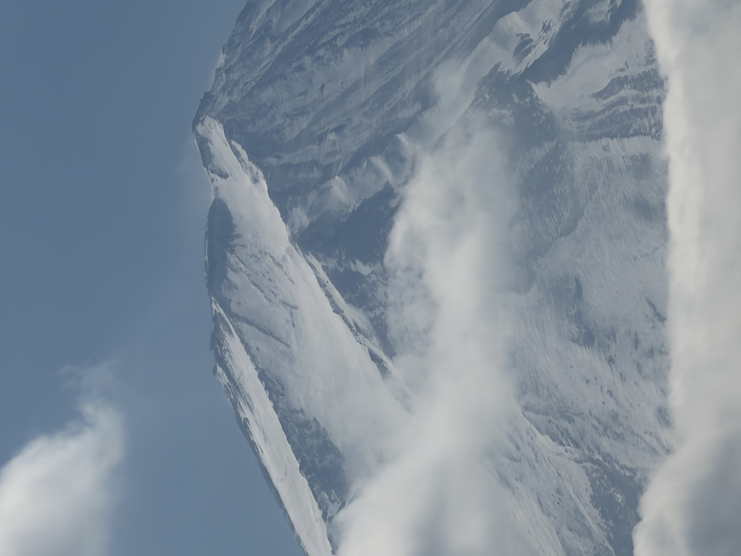 Sommet enneigé du mont Fuji traversé par les nuages