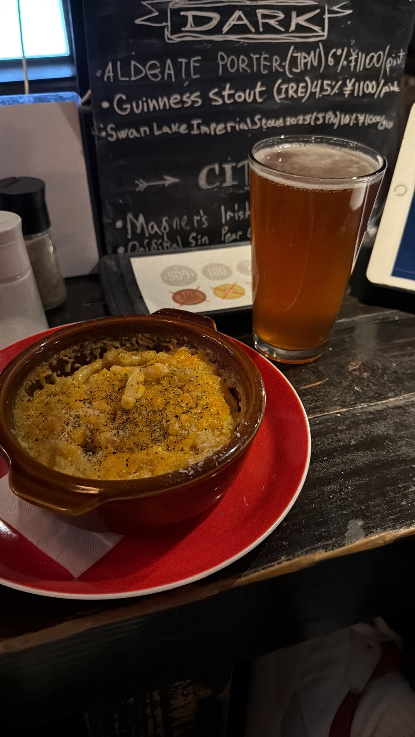 Plat chaud et verre de bière servis au comptoir d'un petit izakaya à Tokyo