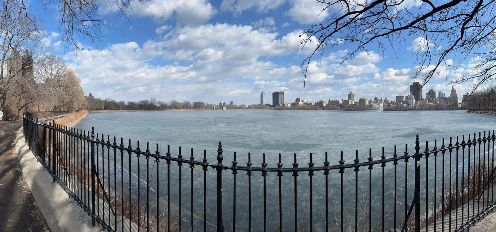 Le réservoir de Central Park gelé, bordé d’arbres sans feuilles et des immeubles de Manhattan.