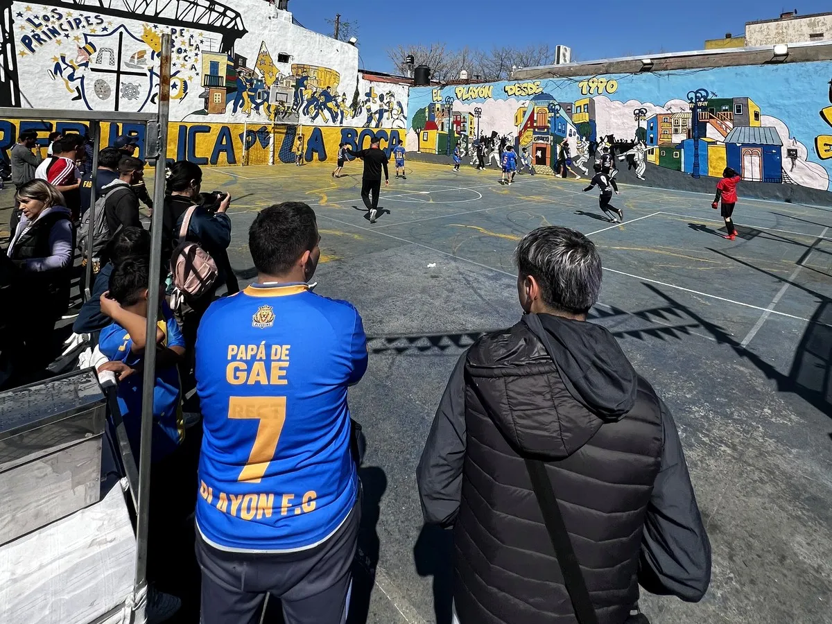Match de football de rue à Buenos Aires, entouré de spectateurs et de vie locale