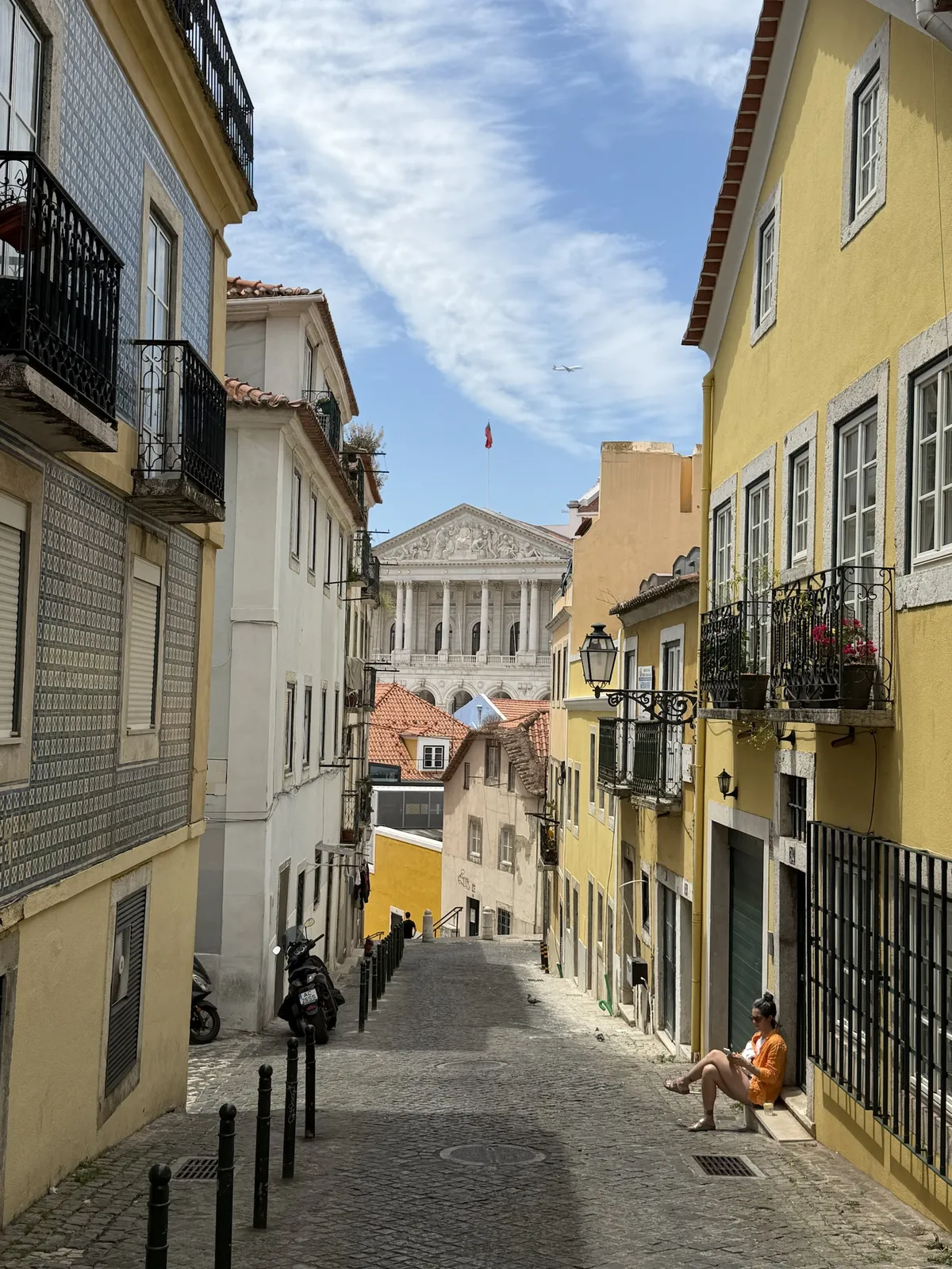 Une ruelle de Lisbonne bordée de façades jaunes et blanches