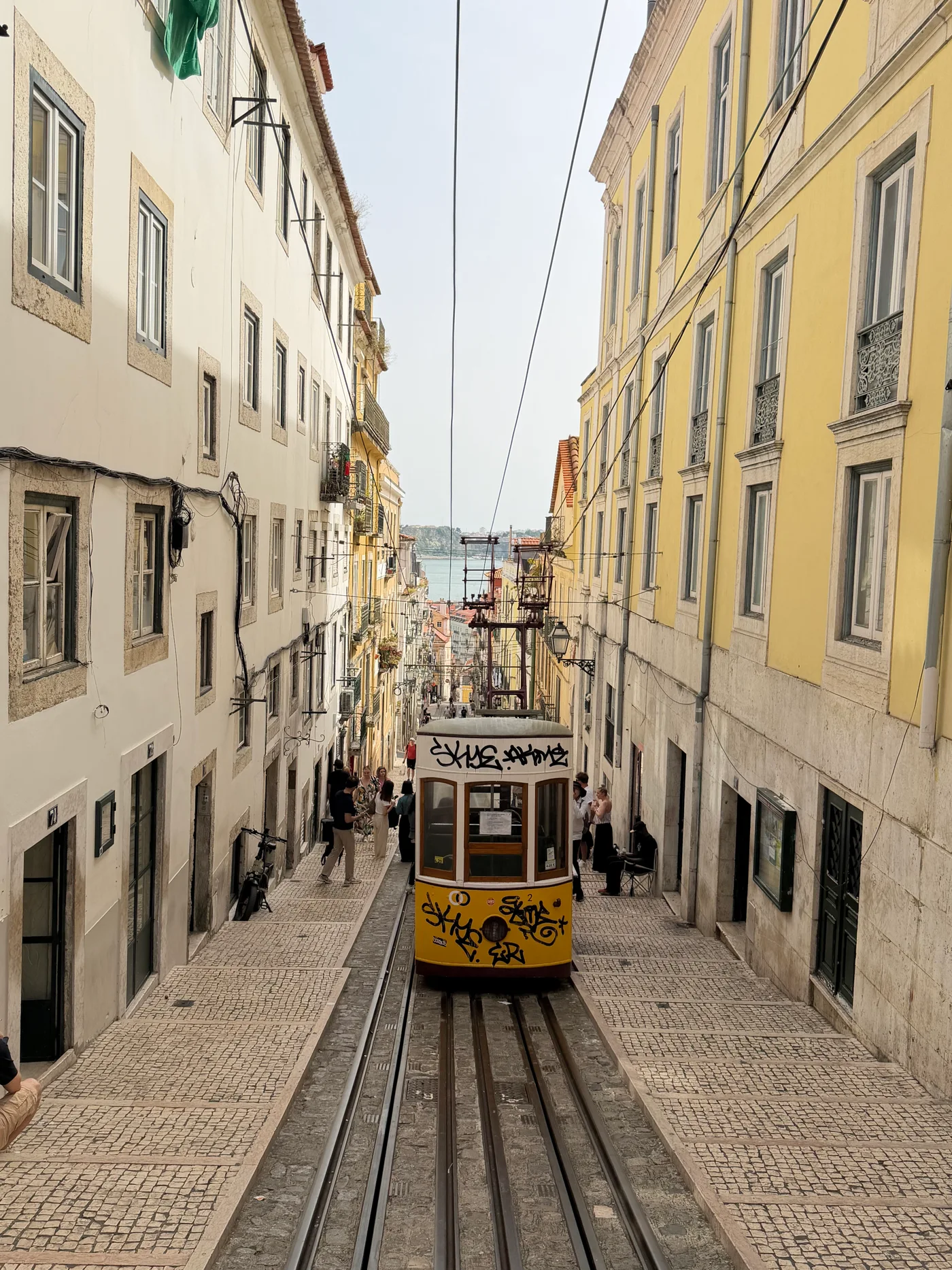 Un funiculaire jaune dans une rue en pente à Lisbonne